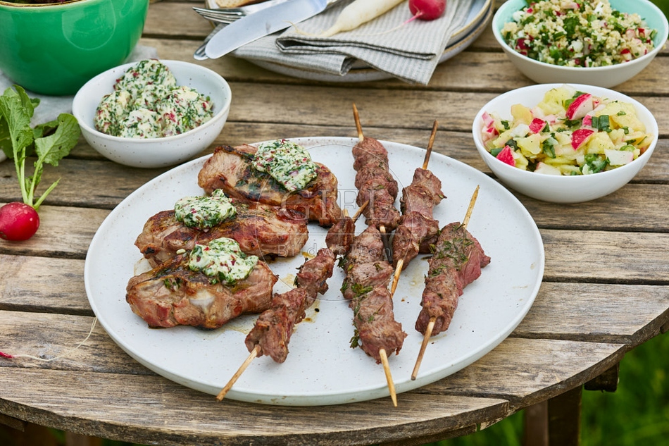 116724 Gedeckter Gartentisch mit gegrilltem Fleisch und Salaten