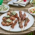 116724 Gedeckter Gartentisch mit gegrilltem Fleisch und Salaten