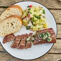 116727 Lammlachse auf Teller mit Kartoffelsalat und Brot